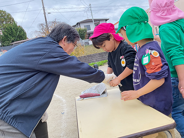 地域の方と一緒にお芋を包む