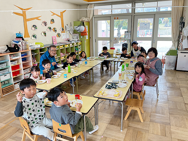 地域の方と一緒に給食を食べる園児たち