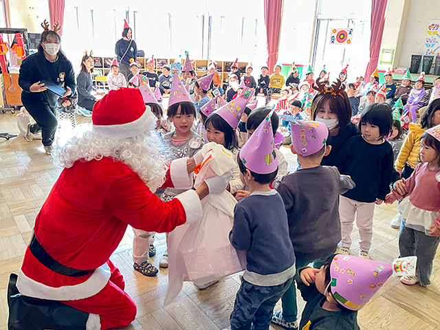 サンタさんからプレゼントをもらう園児たち